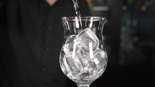 Pouring Liquid Into Glass Filled With Ice