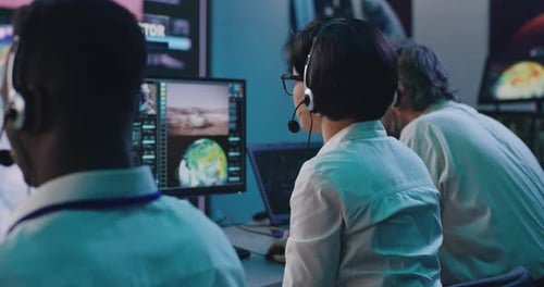 Intense Team Monitoring Space Mission in Control Room