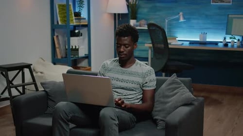 Young Adult Using Laptop Computer at Home