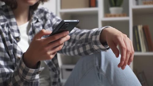 Woman Using Mobile Phone Indoors at Home