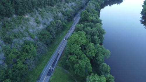 Autos, die auf einer Straße in der Nähe des Flusswassers fahren