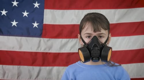 Child Puts on Gas Mask With American Flag