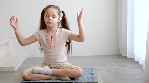 Girl Meditating and Raising Arms Indoors, Close Up