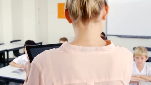 Elementary School Class Raise Hands in Classroom