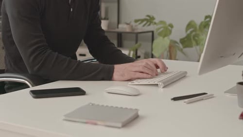 Adult Man Typing on Keyboard in Office