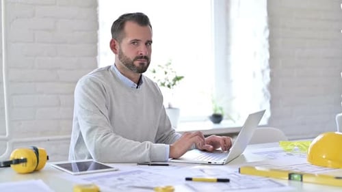 Young Architect with Laptop Shaking Finger in Rejection No