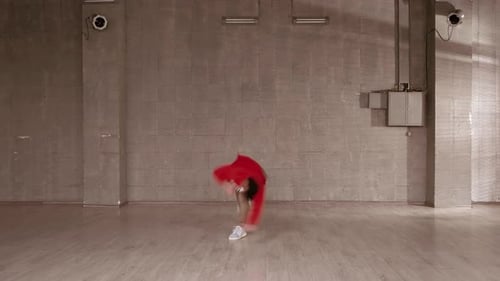 Young Adult Energetically Dancing in a Gray Room