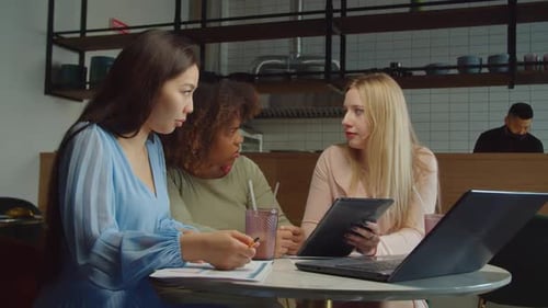 Colegas femeninas ocupadas y diversas que comparten ideas de negocios en un