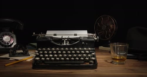Vintage Typewriter, Whiskey, and Rotary Phone on Desk