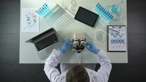 Lab Assistant Adjusting Microscope Objective, Researching Material, Top View