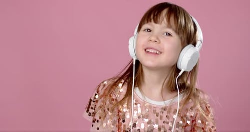 Girl Singing Wearing Headphones on Pink Background