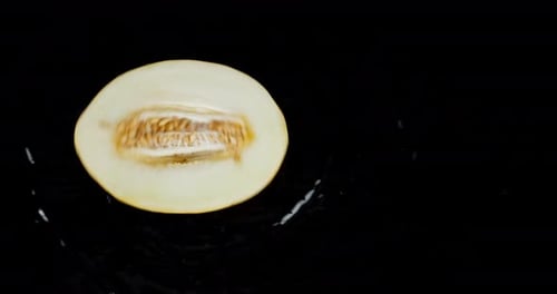 La moitié du melon mûr pivote sur l'eau.