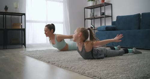 Woman and Child Exercising Together at Home
