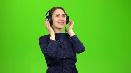 Woman Listens to Music with Headphones on Green Screen