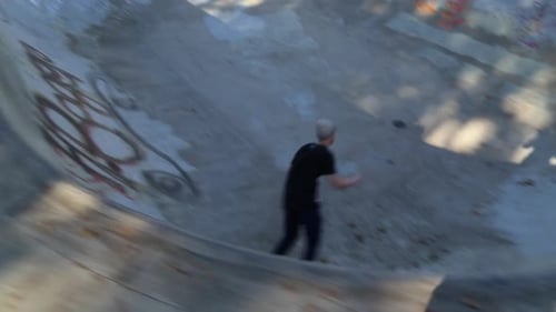 A young skateboarder skating in the bowl of a skate park.