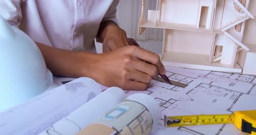 Hands Of Architects Working On Blueprints In The Office