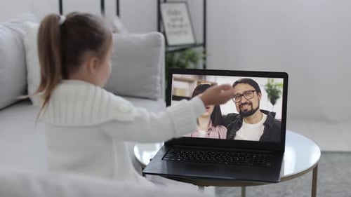 Junges Mädchen sitzt und entspannt sich zu Hause auf dem Sofa und spricht im Videoanruf mit lächelnder Mutter