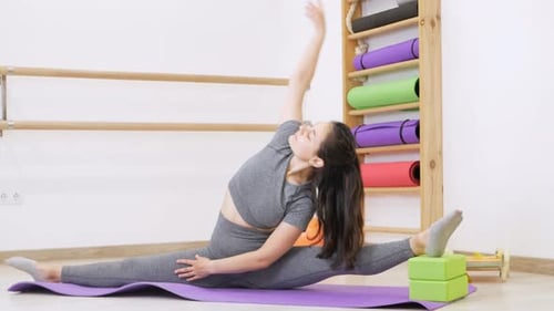 Young Woman is Doing Gymnastics in Gym