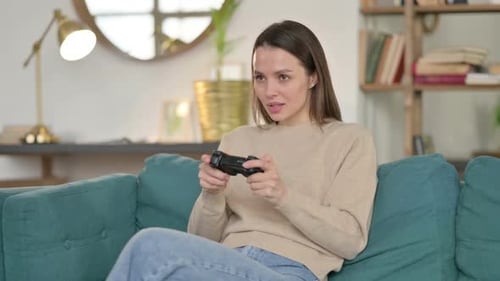 Junge Frau spielt Videospiel auf dem Sofa