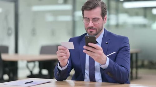 Man Typing On Smartphone At His Desk