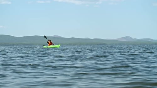 Woman Kayaking on a Serene Lake