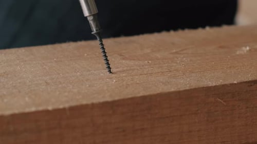 Closeup of a Screwdriver Screwing in a Nail a Selftapping Screw