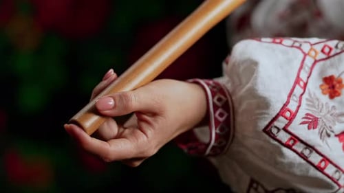 Mão de mulher brincando em madeira, flauta de madeira, telenka ucraniana ou Tylynka em fundo escuro