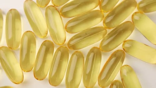 Yellow Gel Capsules for Healthcare on White Surface