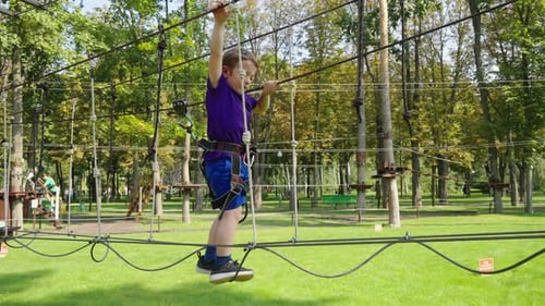 Kid Climbing Rope Trail in Park with Safety