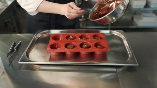 Close-up of chocolate being placed in a baking dish. Brownie preparation.