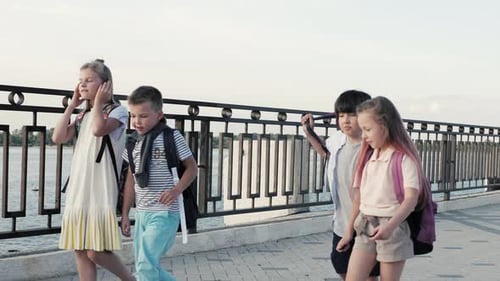 Schoolchildren, a Boys and a Girls, Go To School with Backpacks