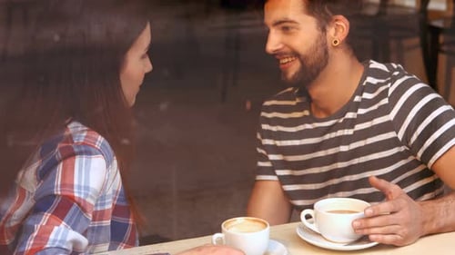 Happy couple interacting with each other while having coffee