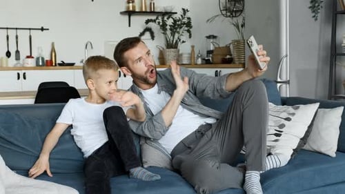 Father and Child Video Chatting on Phone at Home