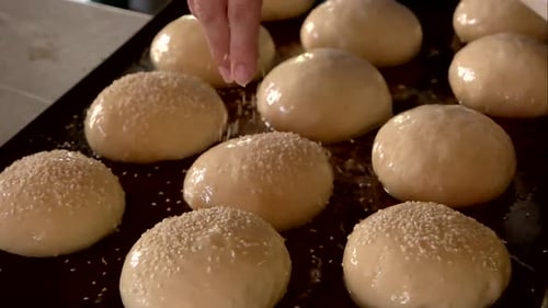 Sprinkling Sesame Seeds on Burger Buns for Baking