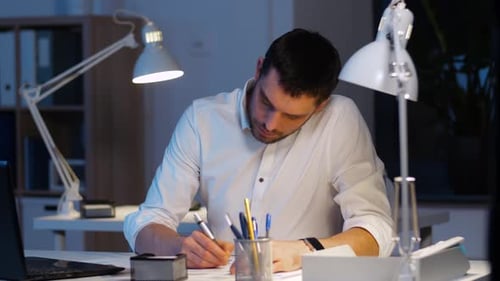 Geschäftsmann mit Akten und Laptop bei Nacht 28