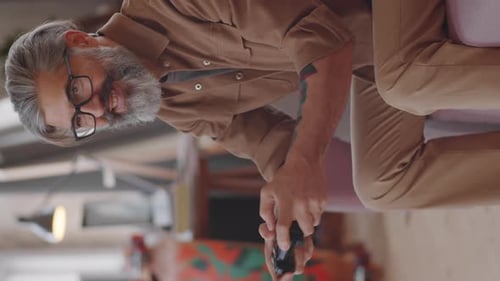 Man with Gray Hair Plays Video Game on Couch