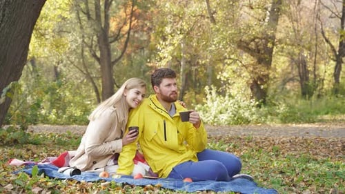 Happy Couple Enjoying Sunny Autumn Day Park They Sit Blanket Look Bright Autumn Trees Around Them