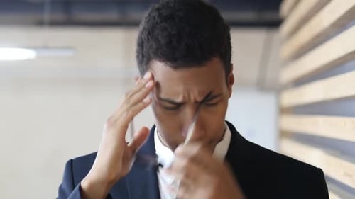 Frustrated, Upset, Tense Businessman with Headache in Office