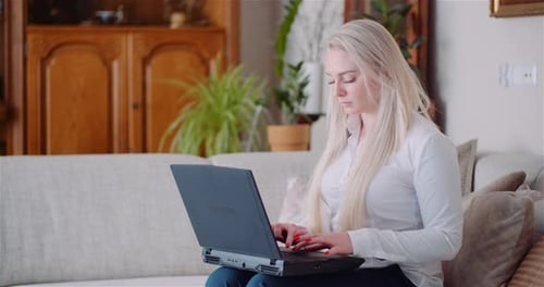 Businesswoman Working on Laptop on a Project at Home Office. Young Woman Using Laptop.