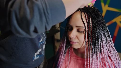 A Female Stylist Attaches Senegalese Braids to a Woman in a Beauty Salon