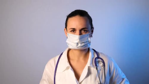 Woman Puts on Surgical Mask and Cap
