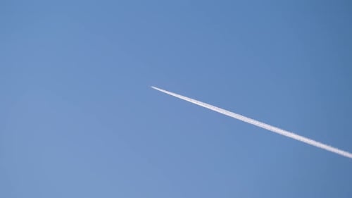 Avion à réaction de passagers volant à haute altitude dans un ciel bleu clair laissant une trace de fumée blanche