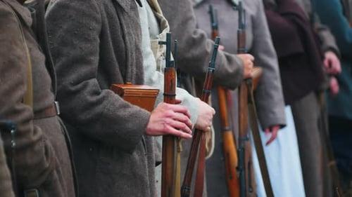 Men Soldiers in Warm Coats Standing in the Row Holding Guns - Autumn Time