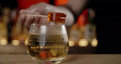 Bartender Adds Topping Marmelade on the Stick to the Cocktail Glass Making the Cocktail at the Bar
