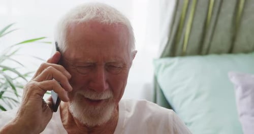 Smiling Senior Man Talking on a Phone Indoors