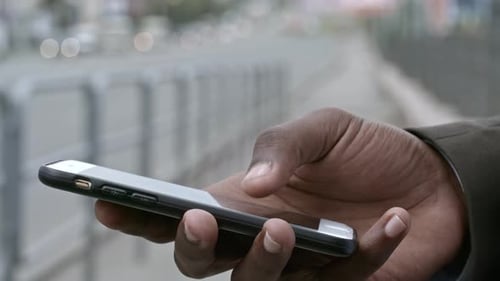 Close Up of Hand of African Man Using Smartphone