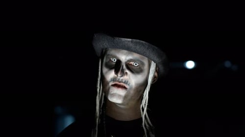 Sinister Man with Skeleton Makeup Appearing From Darkness When Light Falls on Him, Making Faces