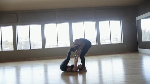 Man and Woman Do Acroyoga in Bright Studio
