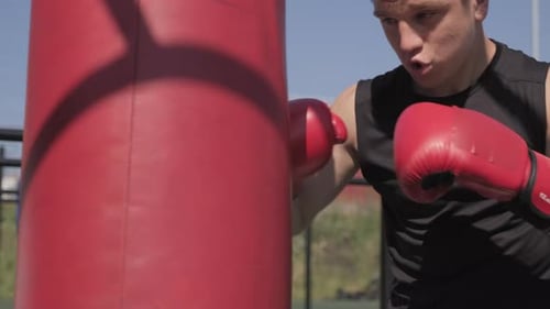 Man Boxing Punching Bag During Outdoor Workout