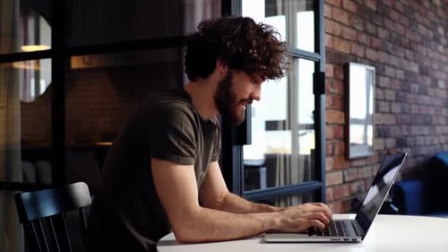 Man Typing on Laptop at Home Office
